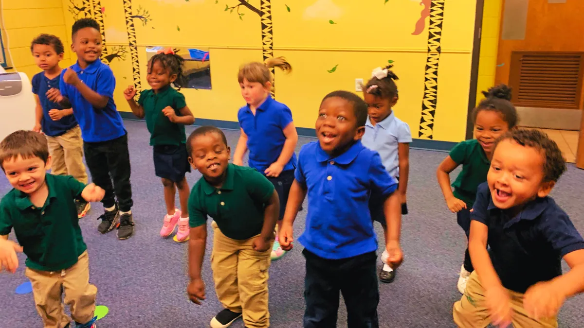 A smiling child being welcomed at the Seeds of Wisdom entrance