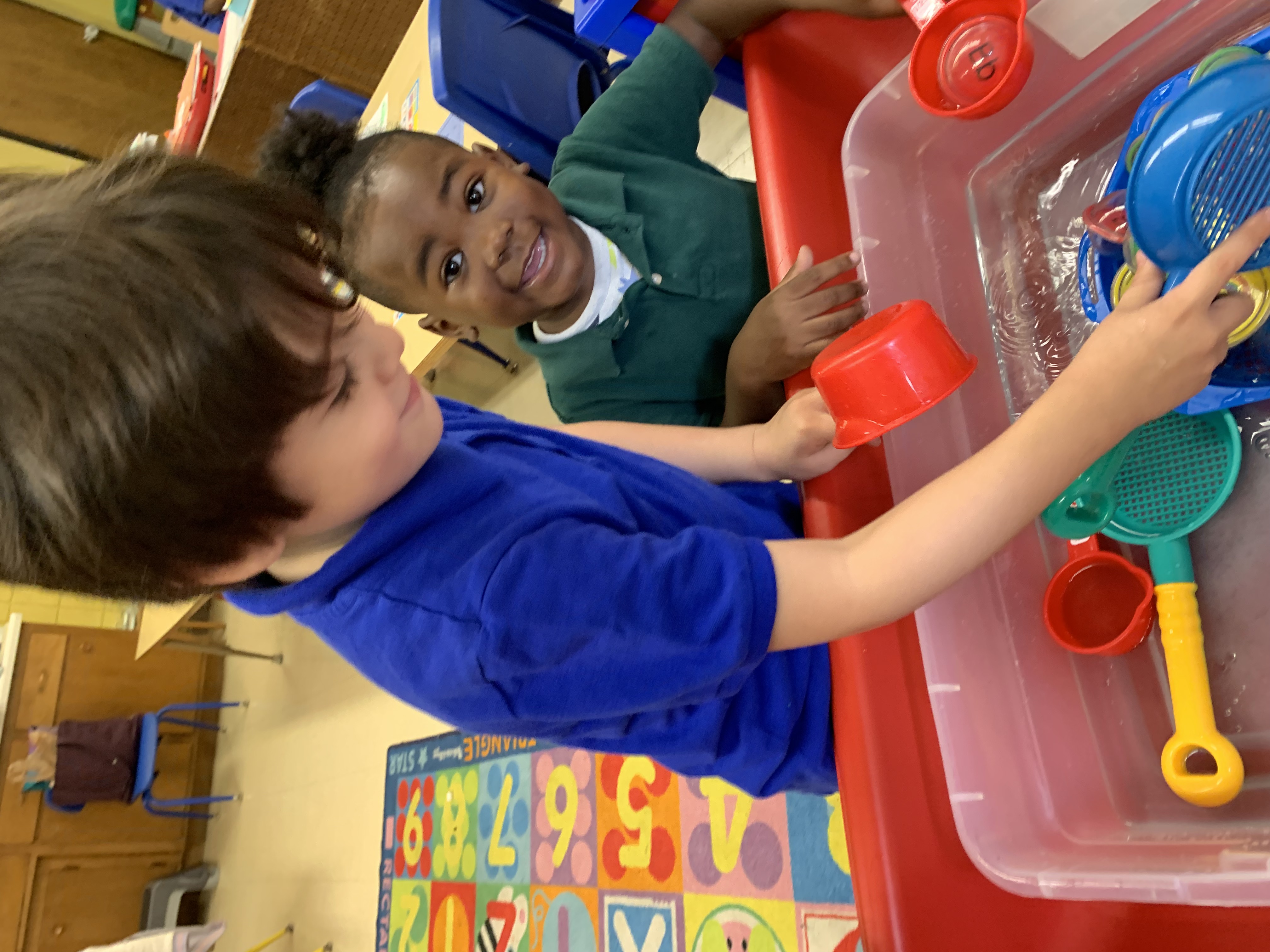 Preschoolers painting at an art table together