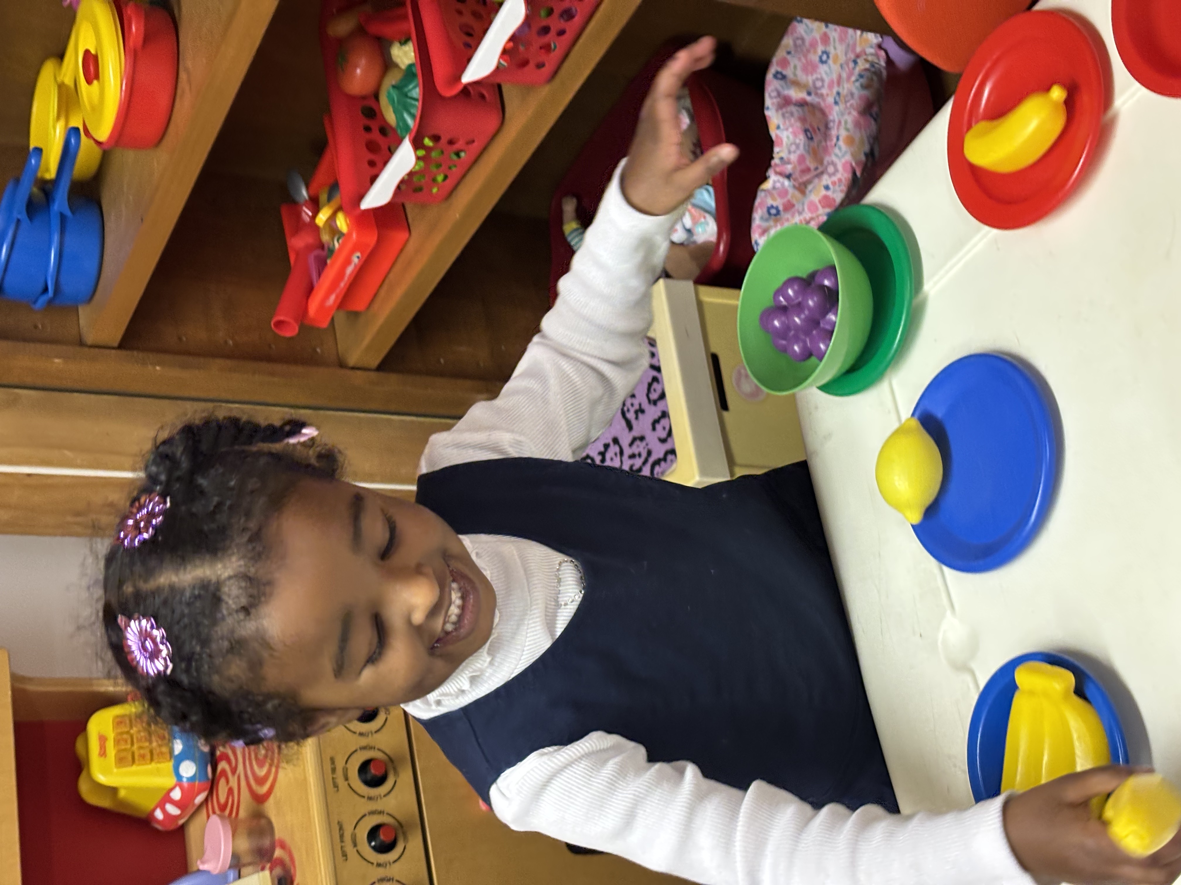 Children painting together at a low table during a Seeds of Wisdom art activity