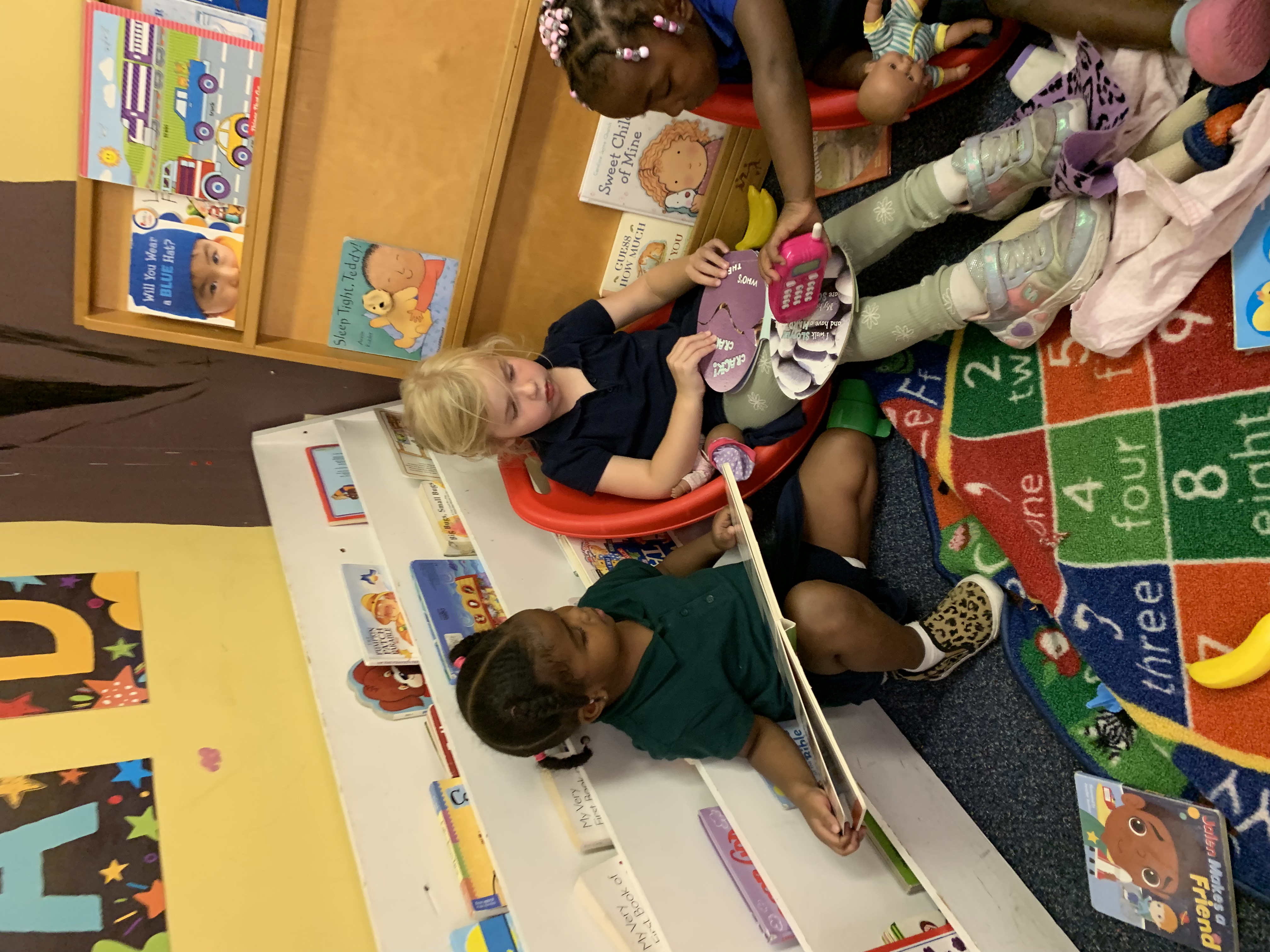 A three-year-old stacking colorful wooden blocks in the Foundations classroom